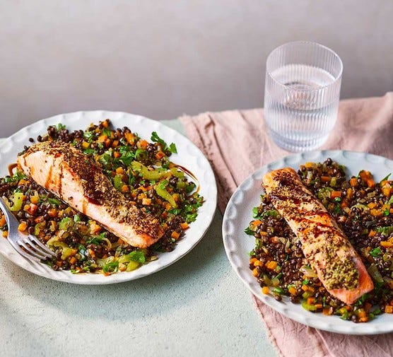 Glossy magazine photo showing two plates of puy lentils with seared salmon