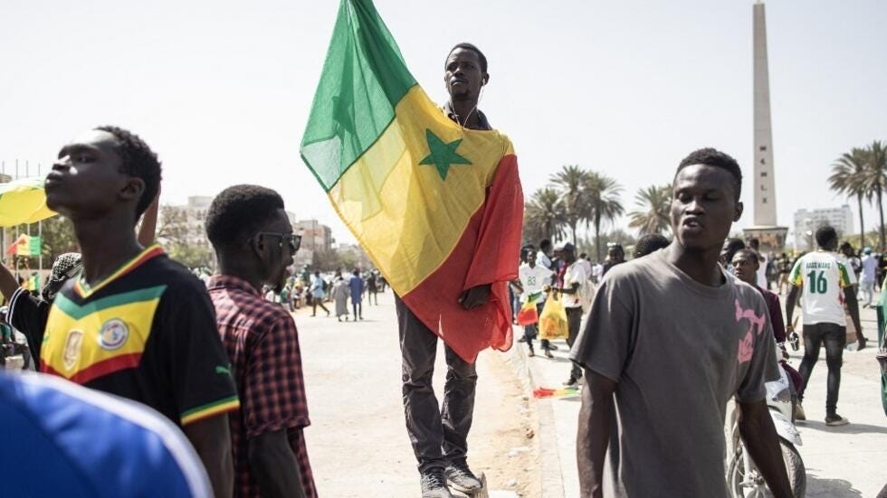 A protester wearing a Senegalese flag during a march against a possible run by the country's incumbent president for a third term in the 2024 presidential election, in Dakar, on 12 May 2023.