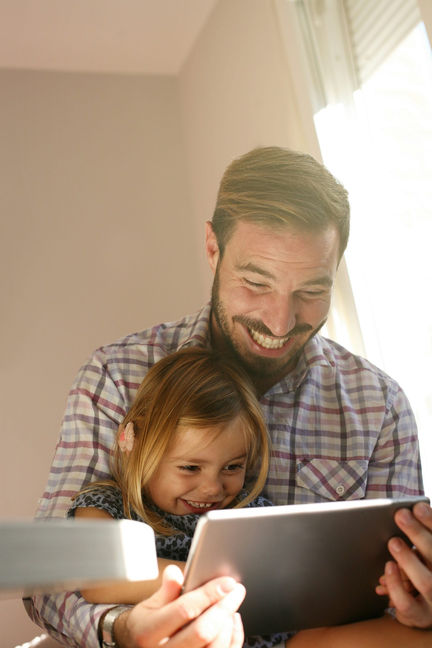 Father and child looking at a computer screen with big smiles