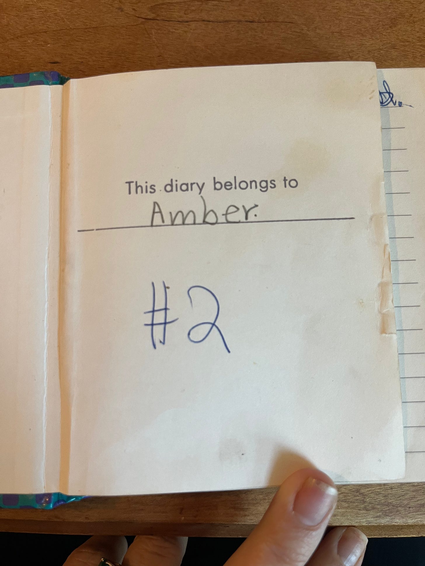 The first interior page of the diary. Text reads: "This diary belongs to Amber" Below that is "#2" written in pen. 
