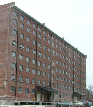 Eight-story brick mill building covered with windows. Eight-story brick mill building covered with windows.