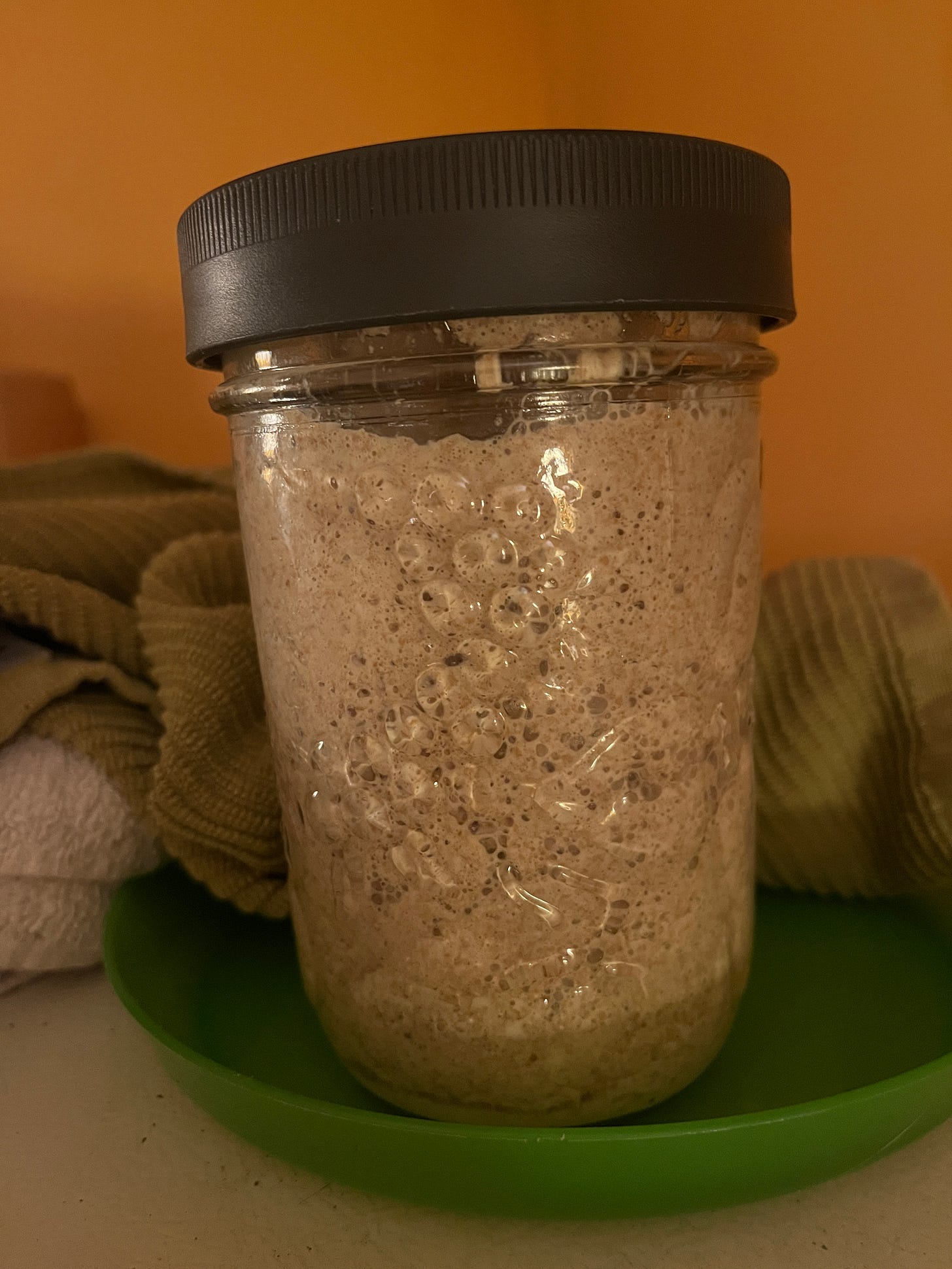 A glass jar of bubbly sourdough starter