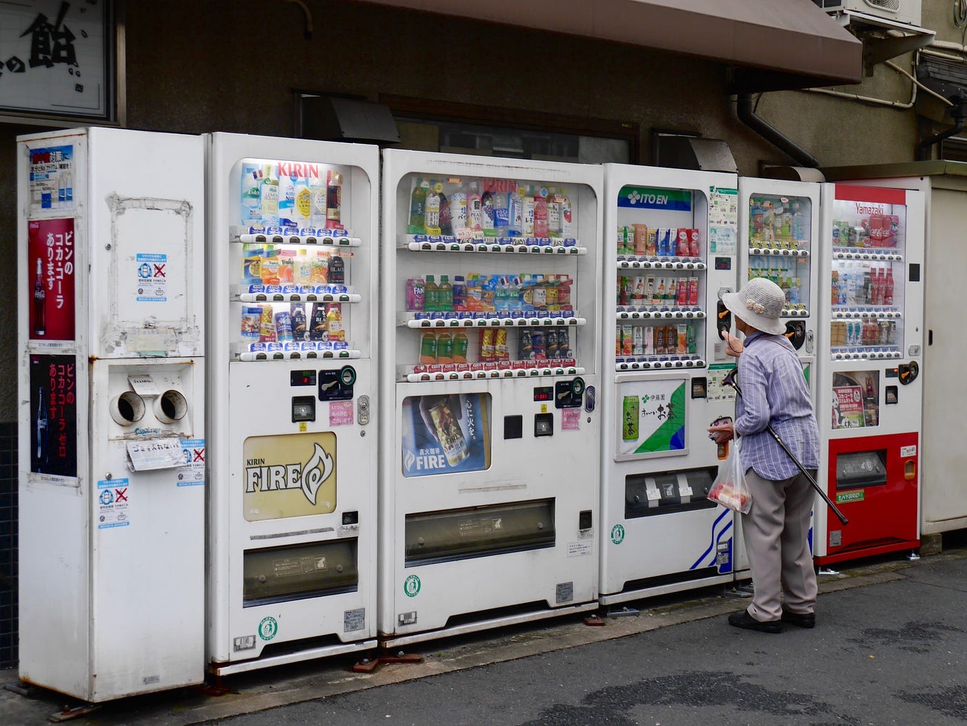 A woman trying to get something from a vending machine.