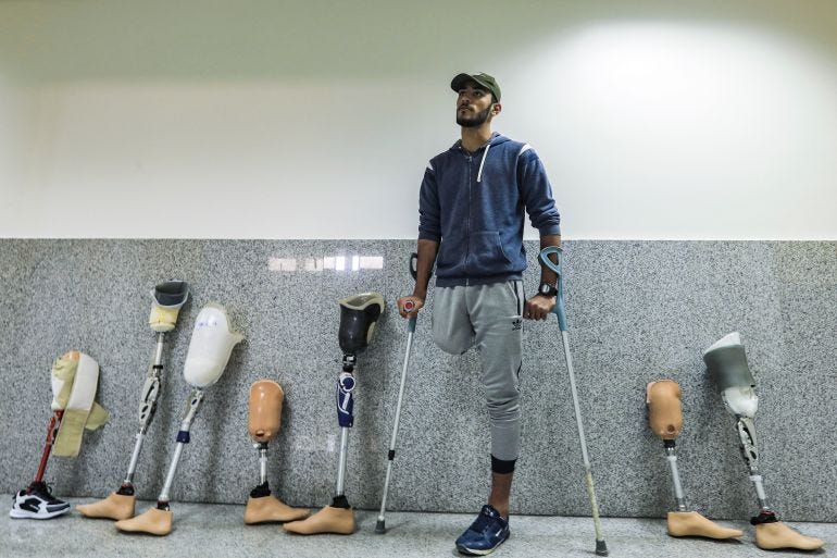 A Palestinian amputee leans on crutches next to prosthetic limbs lined up along a wall while waiting for treatment at the Qatar-funded Sheikh Hamad Bin Khalifa Al-Thani rehabilitation centre in Gaza City A Palestinian amputee leans on crutches next to prosthetic limbs lined up along a wall while waiting for treatment at the Qatar-funded Sheikh Hamad Bin Khalifa Al-Thani rehabilitation centre in Gaza City