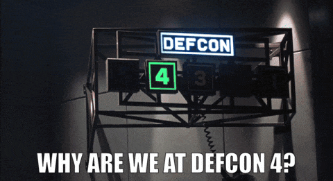 Animated GIF from WarGames. Dabney Coleman asks his assistant "Why are we at DEFCON 4?" while running up the stairs of the facility's nerve center. A green 4 is shown lit on the DEFCON sign.