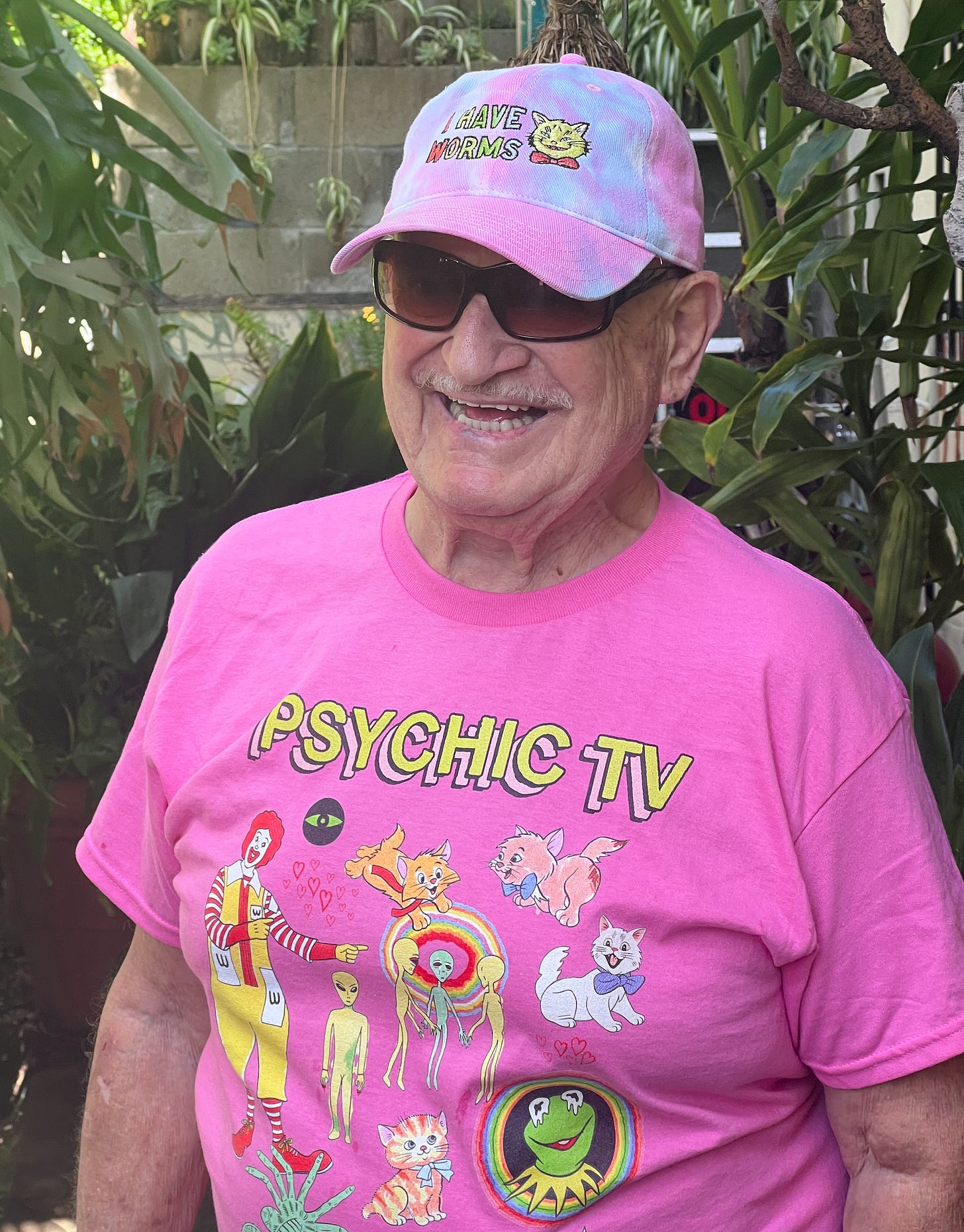 A pink tie dye hat and pink Psychic TV shirt