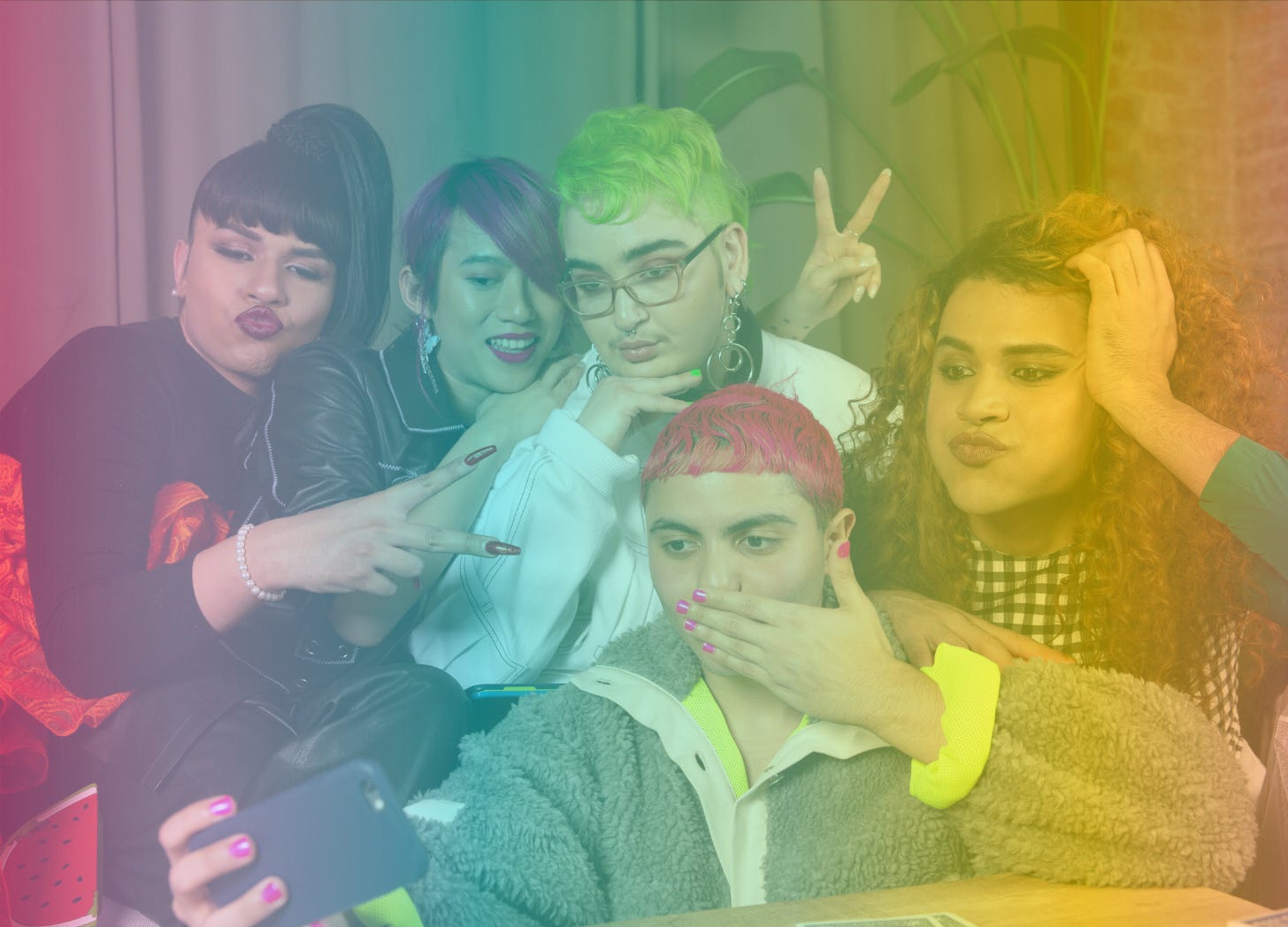 A rainbow-filtered image of a group of queer friends with a variety of different hair colors and styles taking a group selfie together