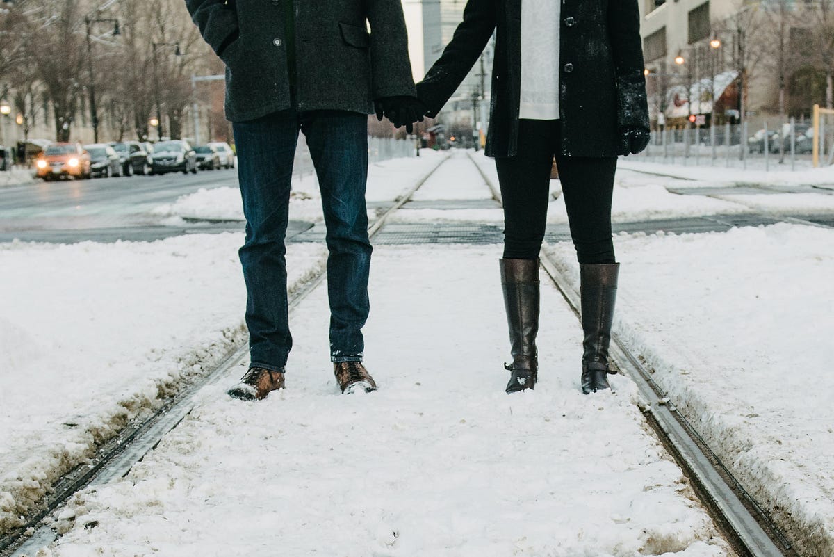 Lovers holding hands on a snowy covered street