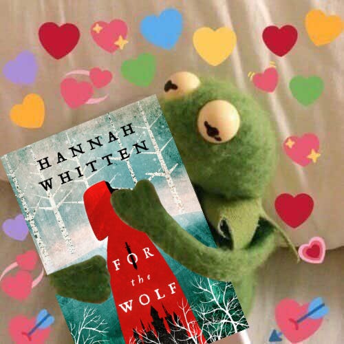 Kermit the Frog hugging a copy of For the Wolf surrounded by emoji hearts.