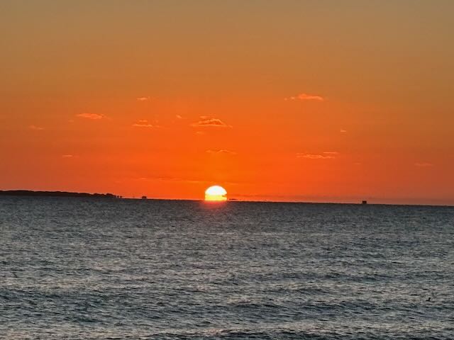 Waves of the Atlantic ocean with the sun rising in an orange red hue