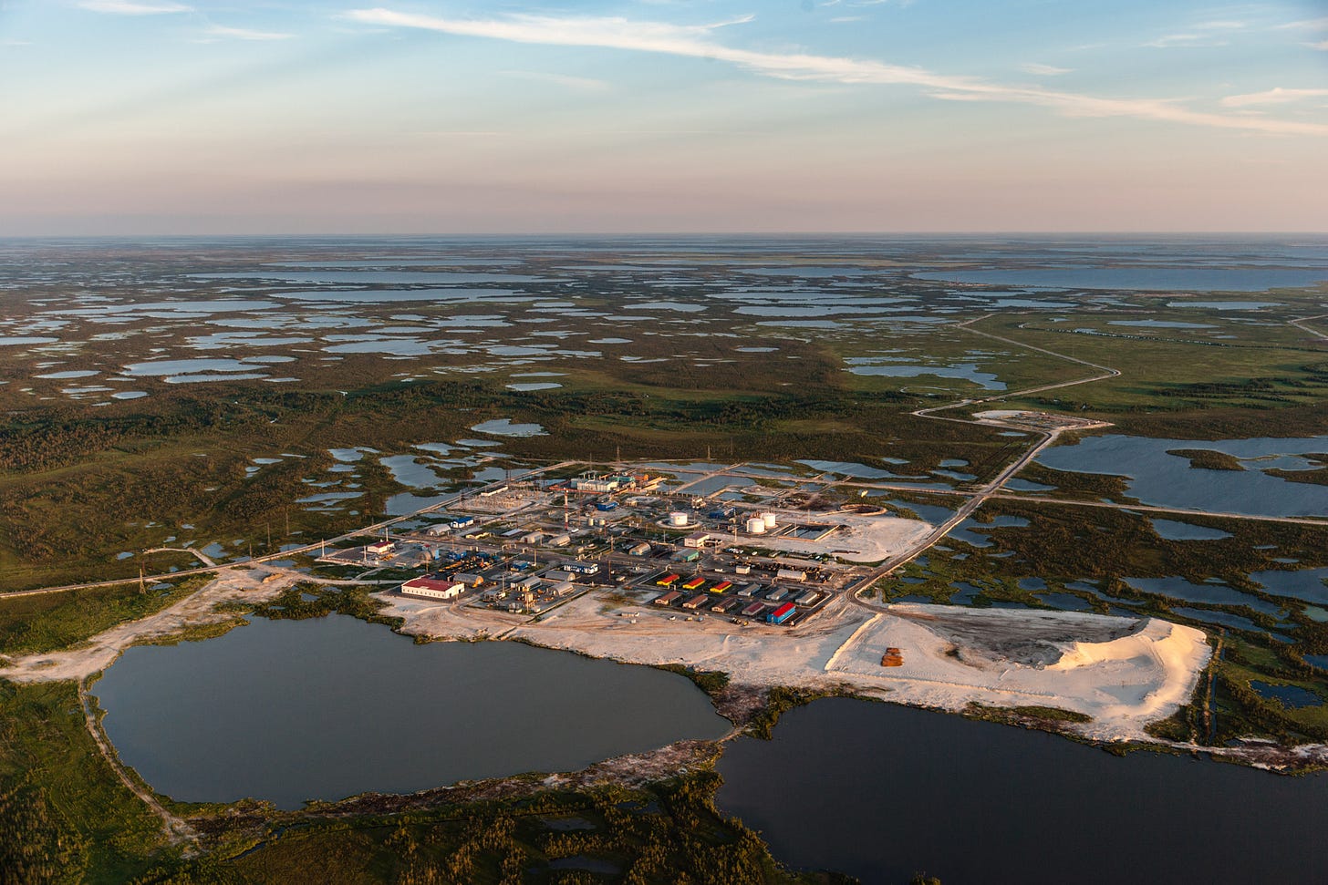 Aerial view of oil operation and pipeline in the midst of thawed permafrost lakes.