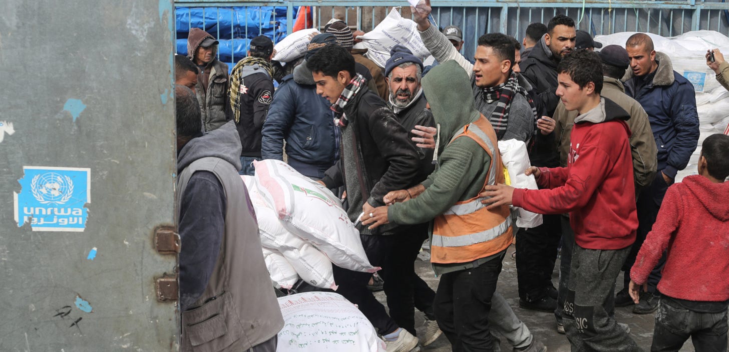 RAFAH, GAZA - JANUARY 28: Palestinians, who left their homes and took refuge in Rafah city under hard conditions, carry the flour they received at the area where UNRWA (The United Nations Relief and Works Agency for Palestine Refugees) distributes flour to families as Israeli attacks continue in Rafah of Gaza on January 28, 2024. Palestinians face severe water and food shortages due to Israeli attacks and new restrictions. (Photo by Ahmed Zaqout/Anadolu via Getty Images) RAFAH, GAZA - JANUARY 28: Palestinians, who left their homes and took refuge in Rafah city under hard conditions, carry the flour they received at the area where UNRWA (The United Nations Relief and Works Agency for Palestine Refugees) distributes flour to families as Israeli attacks continue in Rafah of Gaza on January 28, 2024. Palestinians face severe water and food shortages due to Israeli attacks and new restrictions. (Photo by Ahmed Zaqout/Anadolu via Getty Images)