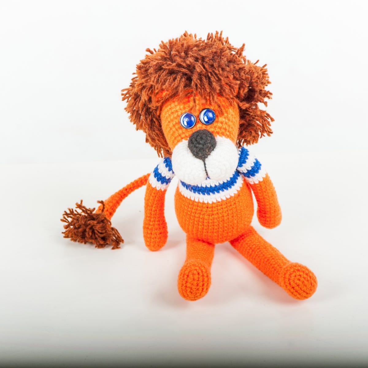 Photo of soft toy lion - orange with blue and white striped t shirt