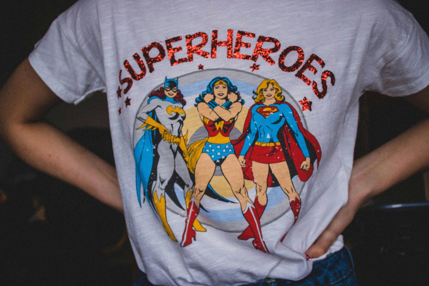 Person wearing a shirt depicting multiple superhero characters