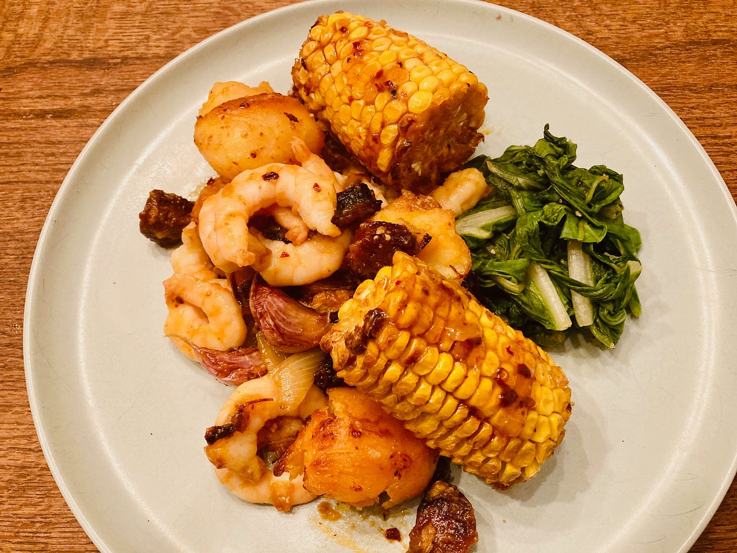 A traybake of chorizo and prawns with sweetcorn and greens