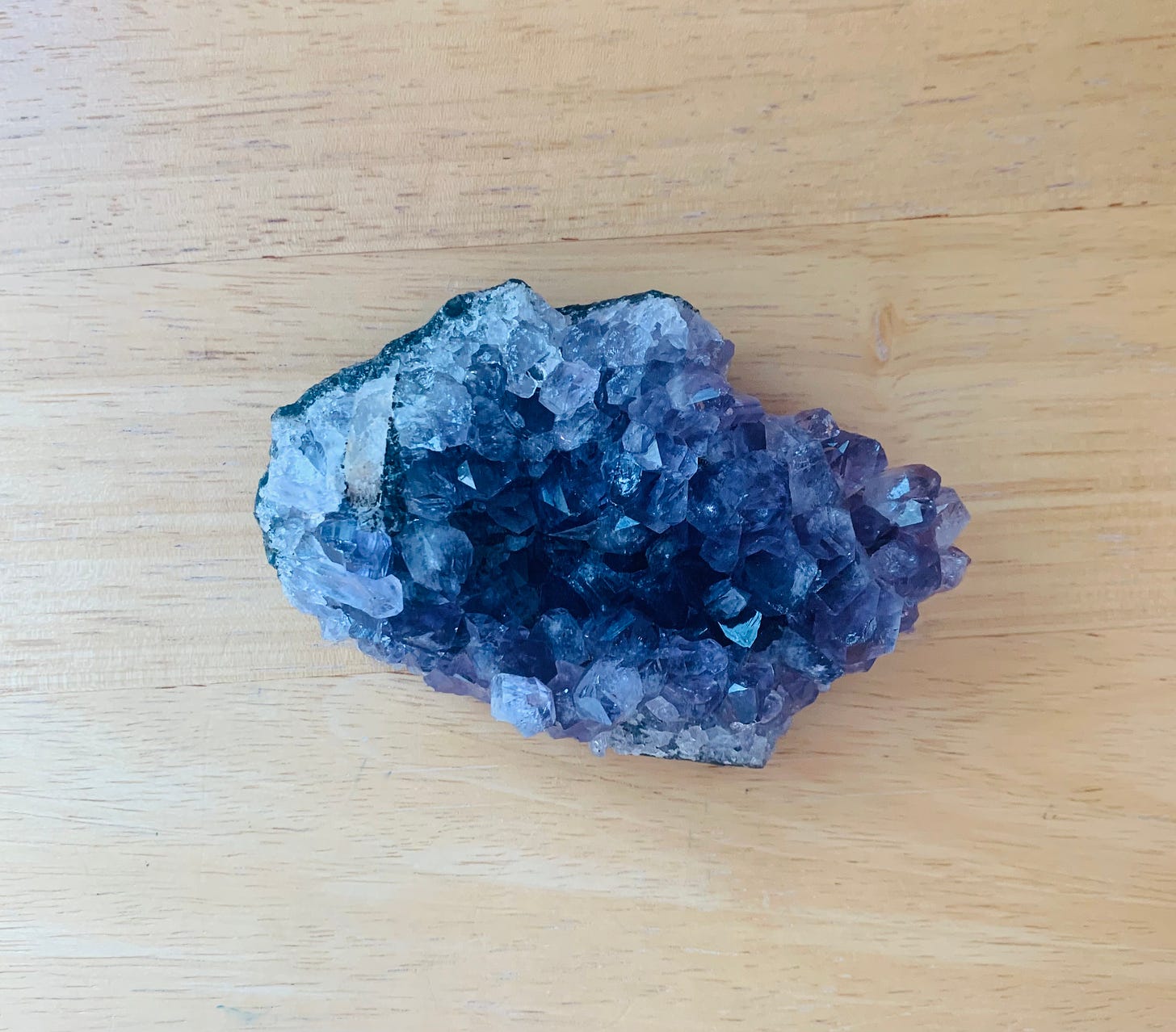 Amethyst geode on a light wood table