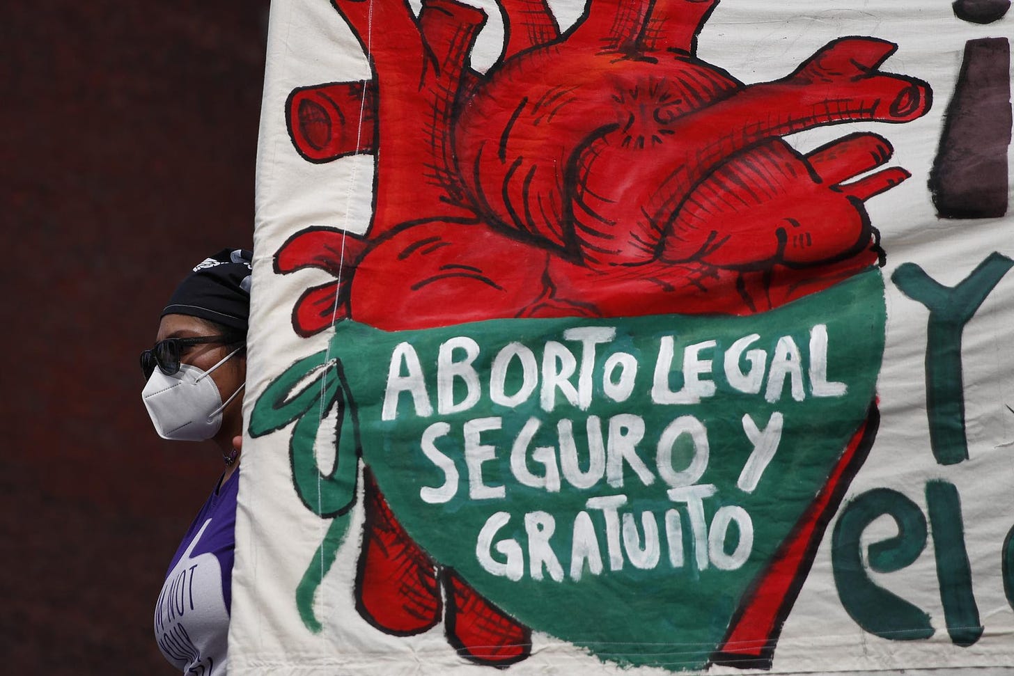 A woman holds a banner reading in Spanish, ''Legal, safe, and free abortion'' in Mexico City. 