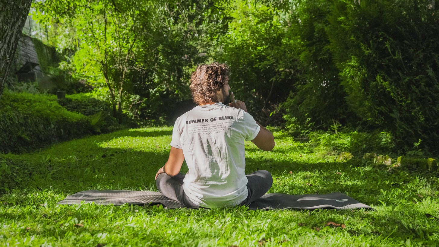 a man sitting on a yoga met in the grass