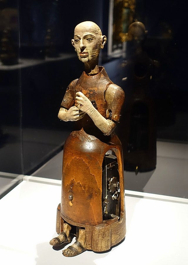 An automaton of a monk, wooden, 16th century, in a display cabinet