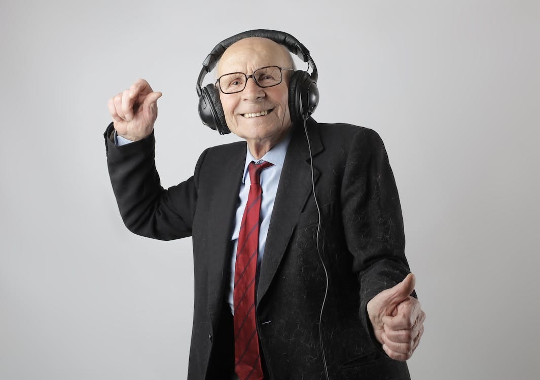 Free Cheerful elderly man listening to music in headphones Stock Photo