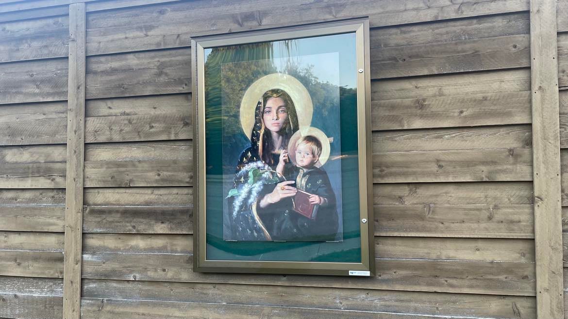 A framed painting of a haloed woman holding a haloed boy