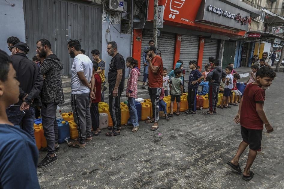 Palestinians stand in line to get water in the city of Rafah in the southern Gaza Strip amid ongoing hostilities between Israeli forces and Palestinian armed groups, November 13, 2023. 