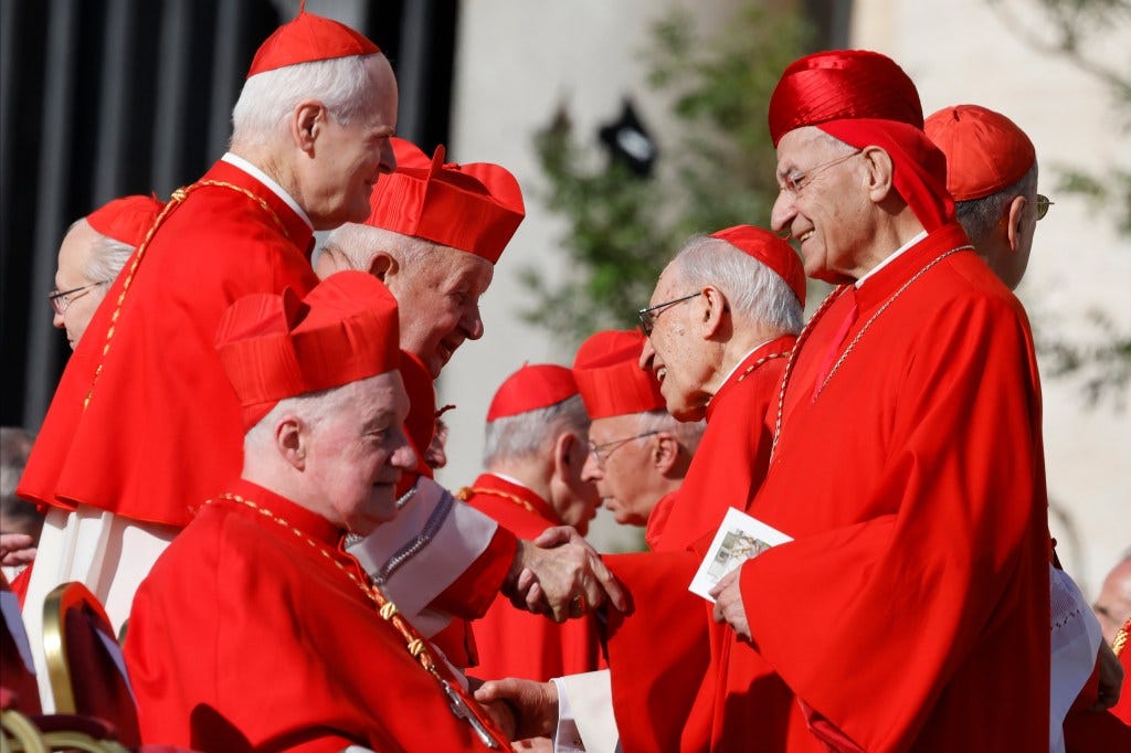 The cardinals shaking hands. 