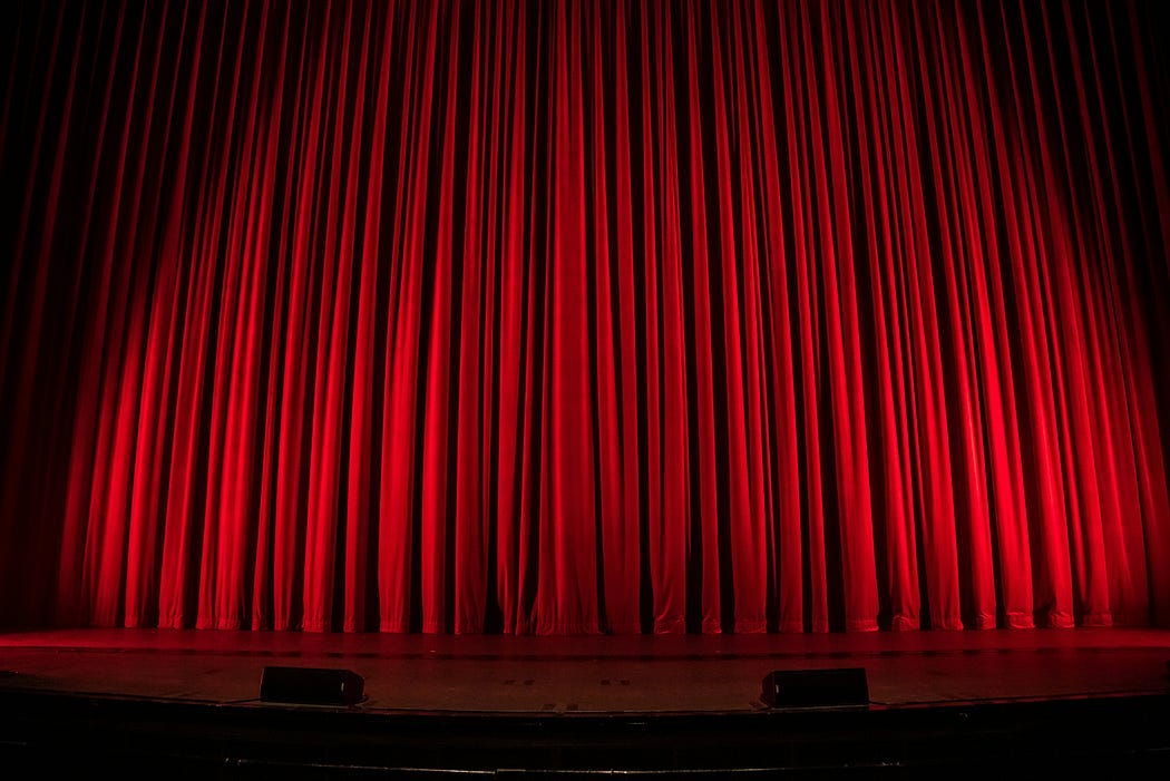 theater stage. red curtains closed, prepared for the start of the show.