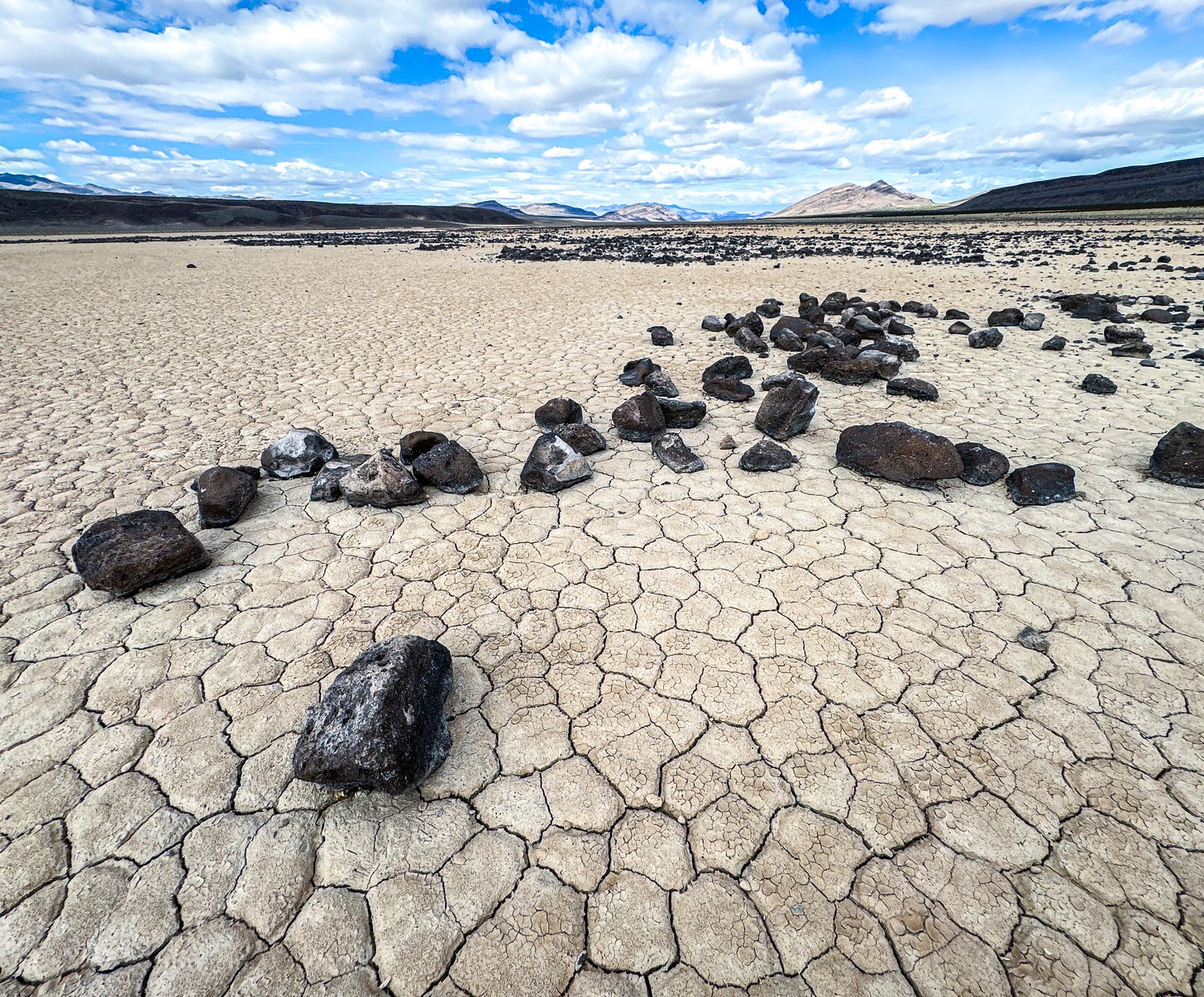 dry lake bed with rocks and cracked mud