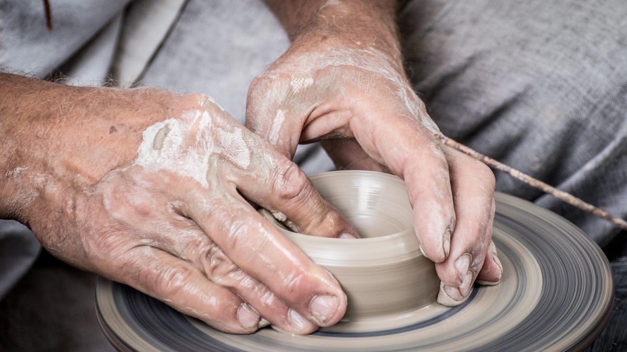 A potter molding a pot out of clay.