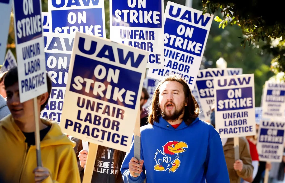 Photo of striking UC grad workers, all holding UAW On Strike signs