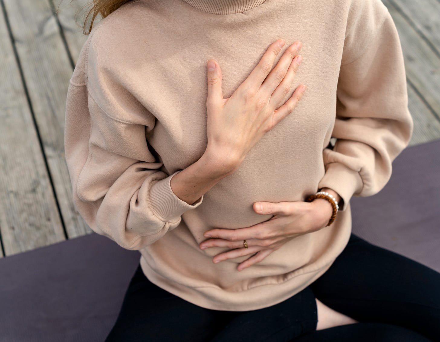 image of a woman breathing, one hand on chest, one on belly