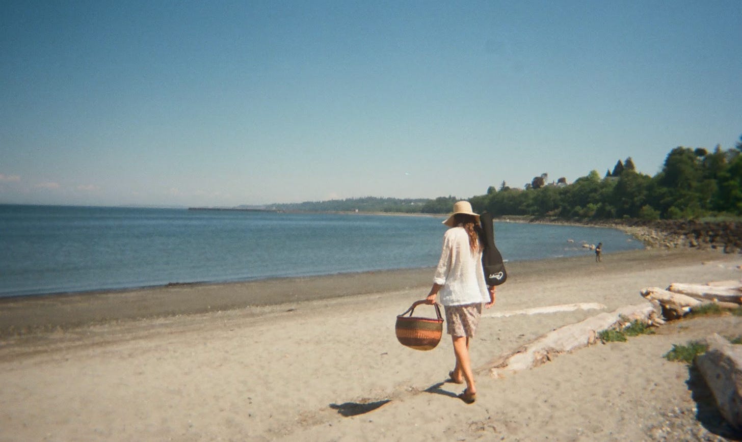 Brunette walks on beach holding a basket