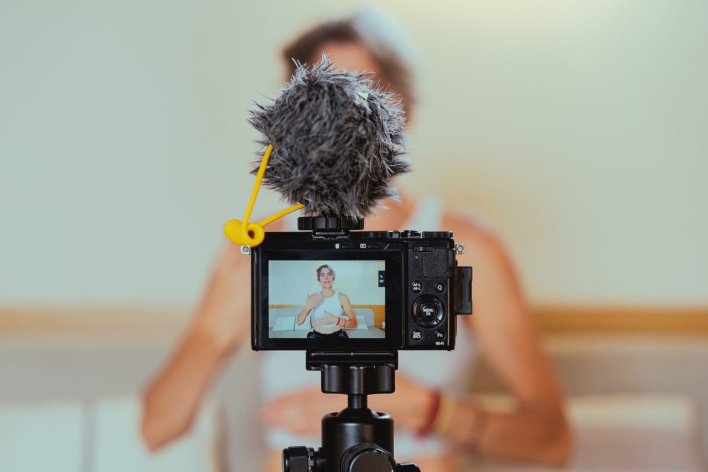 A woman recording herself using a vlogging camera