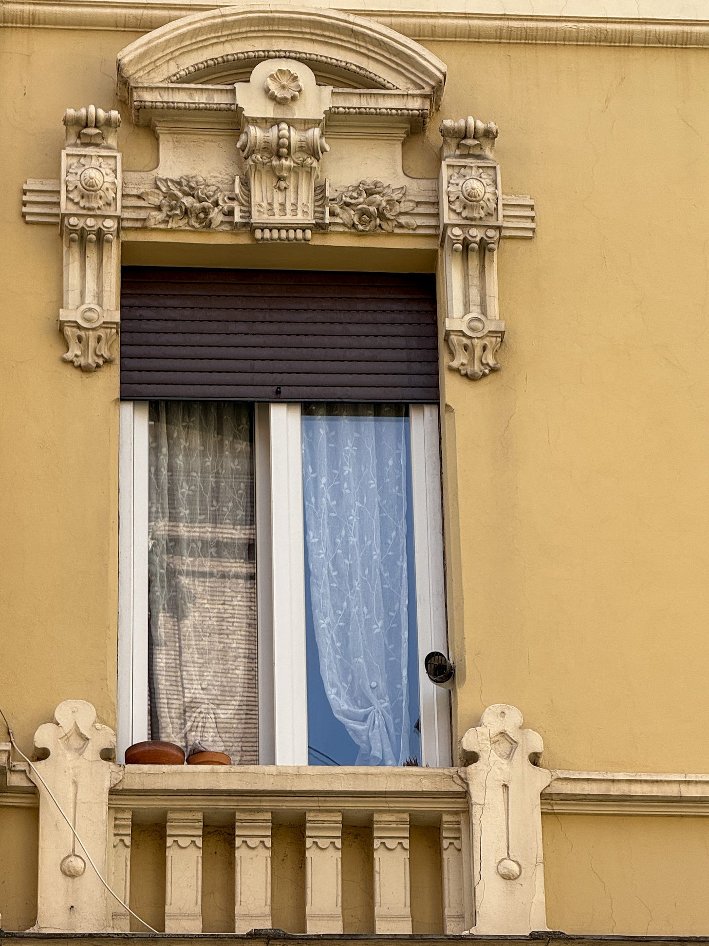A layered reflection of Roman buildings captured in a yellow-orange tinted window, playing with color and form. A layered reflection of Roman buildings captured in a yellow-orange tinted window, playing with color and form.