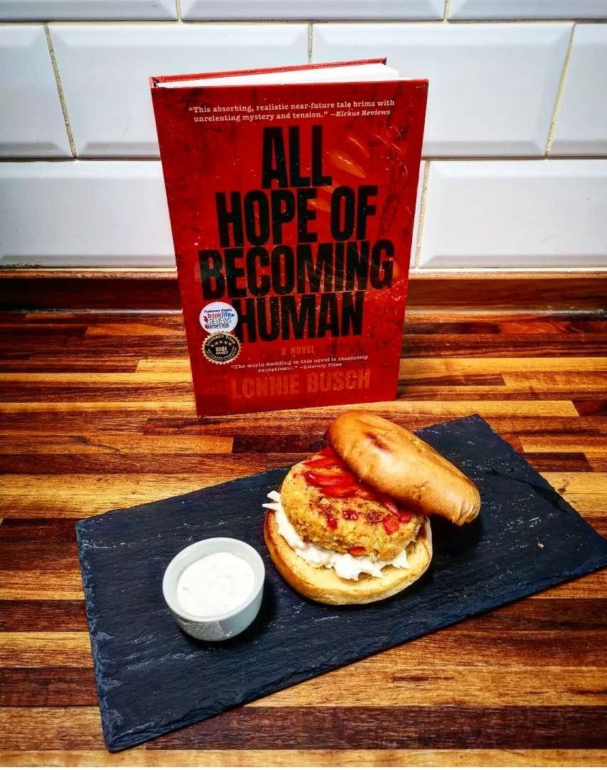the book all hope of becoming human next to a very tasty looking sandwich