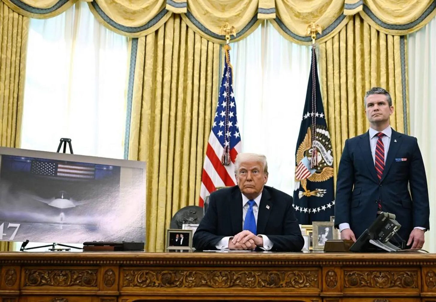  US President Donald Trump and Secretary of Defense Pete Hegseth listen during an event in the Oval Office of the White House in Washington, DC, on March 21, 2025. Trump announced the award to Boeing of a major contract for the Air Force's high-tech next-generation F-47 fighter plane. (AFP) 