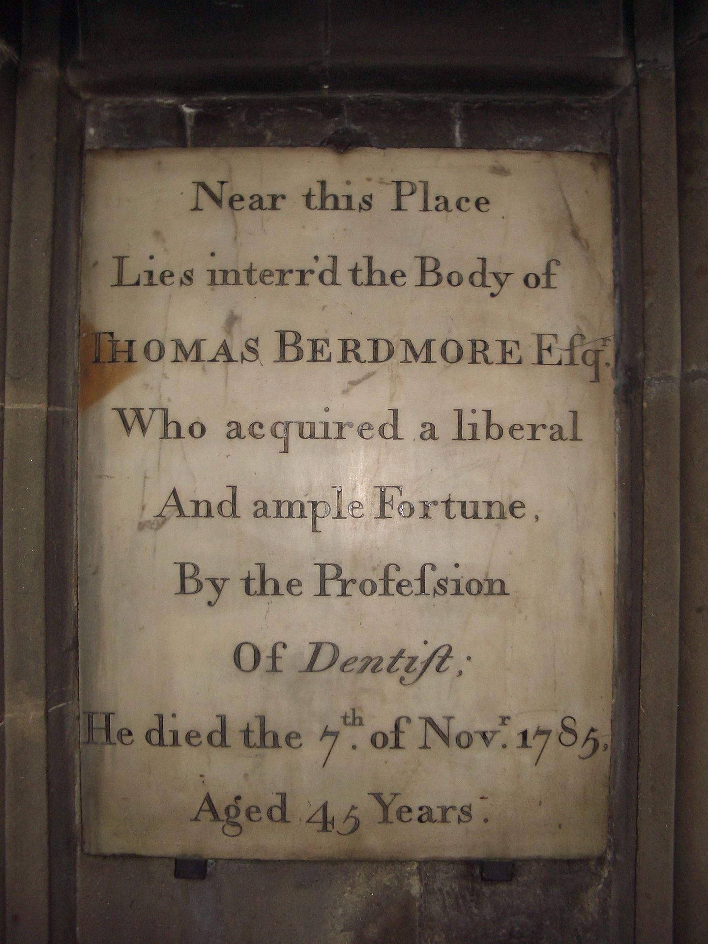 A memorial plaque to Thomas Berdmore. It says that 'he acquired a liberal and ample fortune by the profession of dentist.'