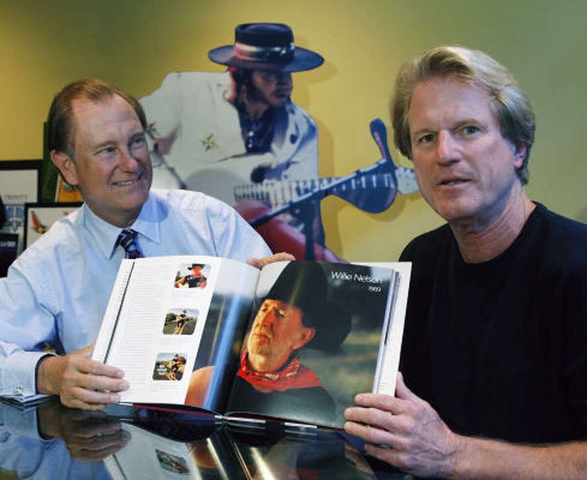 Tim McClure, left, and Roy Spence display their book, Don't Mess with Texas: The Story Behind the Legend. They run GSD&M, the Austin ad agency that perfected the slogan 20 years ago. A cutout of the late Stevie Ray Vaughan, who participated in the first TV spot, is behind them.