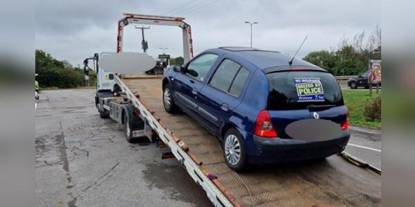Vehicle with a seized sticker being taken away on a loader