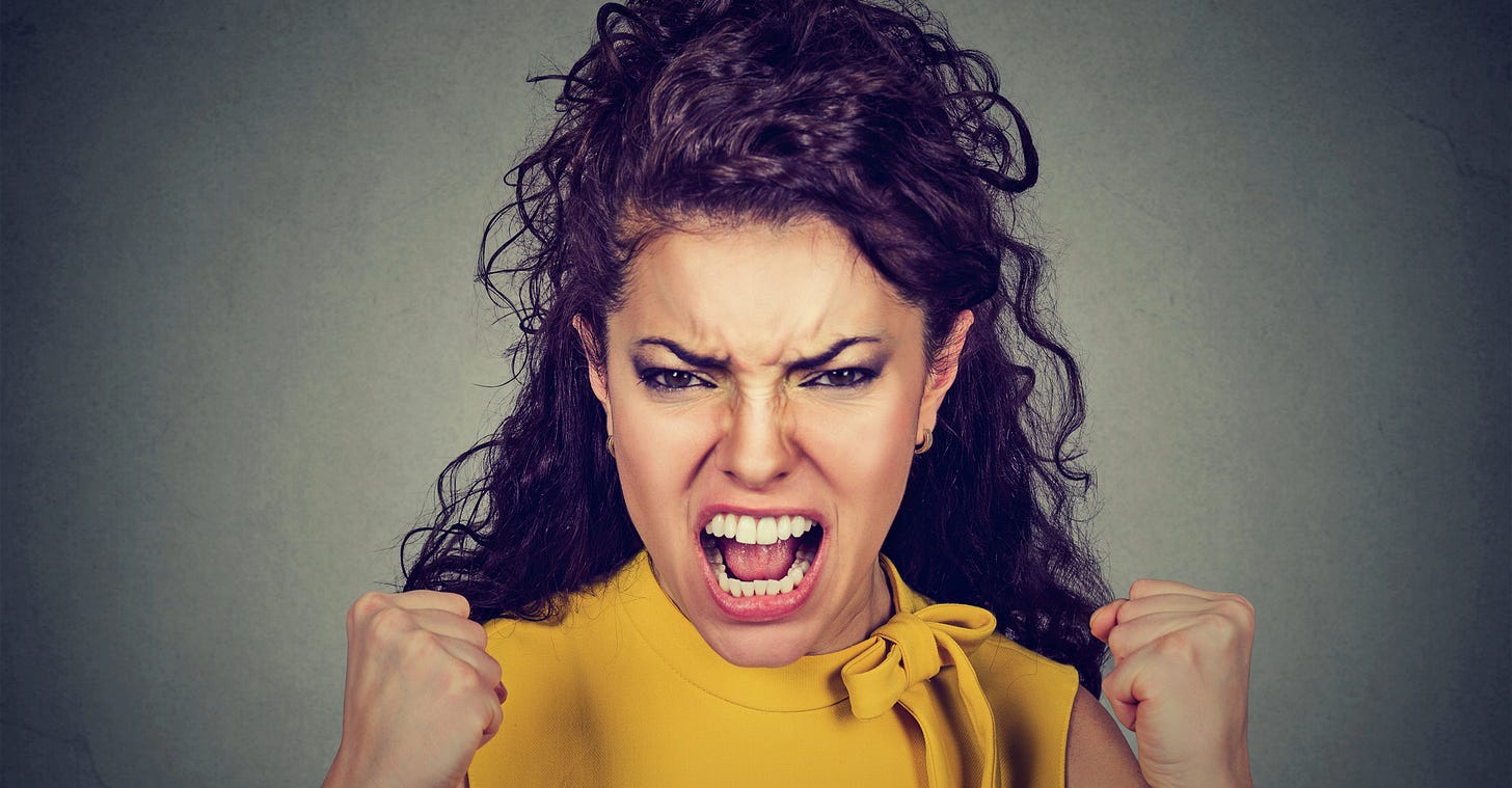 Close up of angry woman with long wavy hair and a yellow dress, fists raised