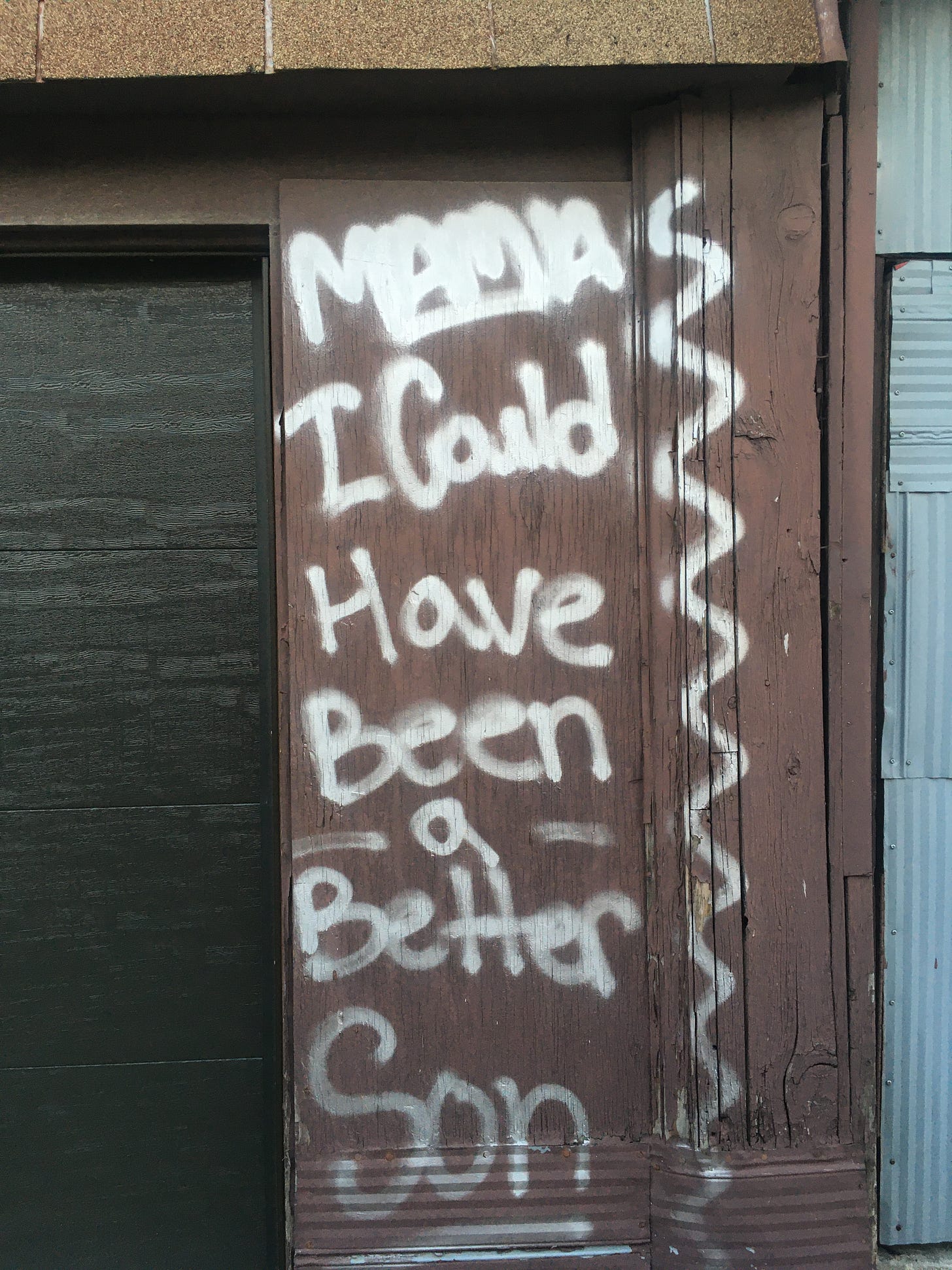 Graffiti on a wall reads "Mama, I could have been a better son".