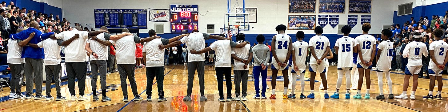 Members of the John Marshall High School Basketball team line up on the court before the game