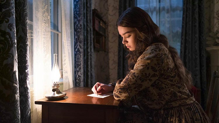 Imagem da série Dickinson: Emily Dickinson, a protagonista, escreve em sua mesa.