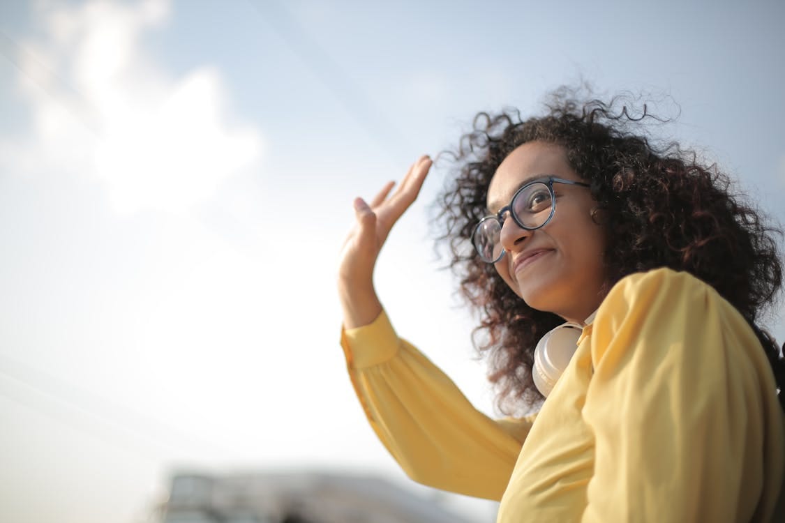 Free Woman in Yellow Top Waving Stock Photo