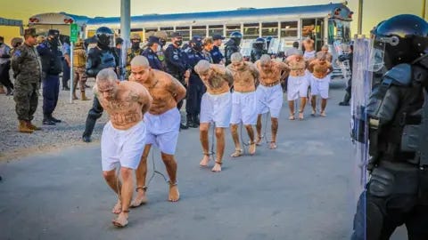 Reuters Prison agents observe gang members as they get off a bus at their arrival after 2000 gang members were transferred to the Terrorism Confinement Center