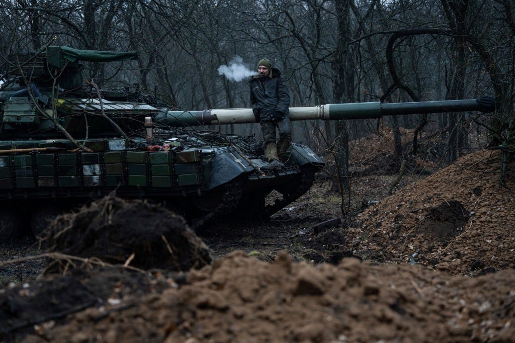 A Ukrainian serviceman smokes a cigarette standing atop a tank near Bakhmut, Ukraine on March 8, 2023.