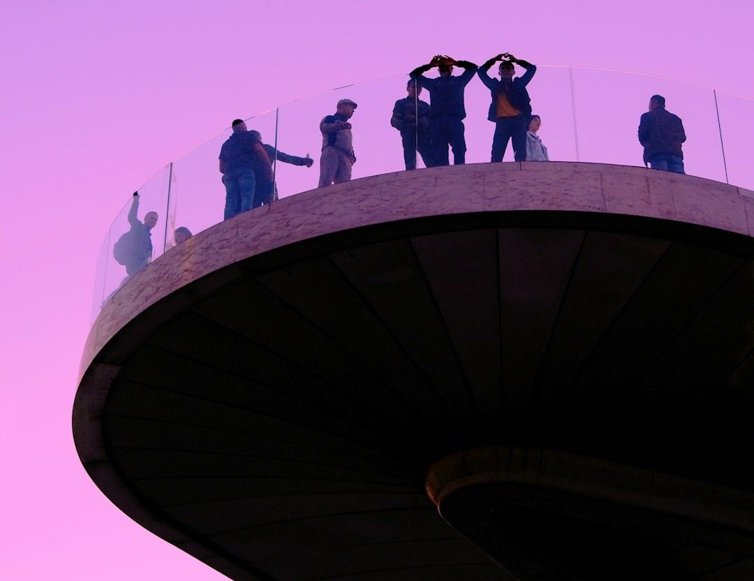 a group of people standing on top of a tall building
