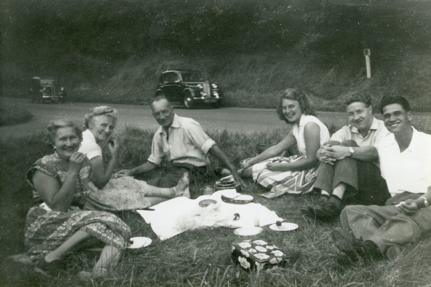 An black and white image of family having a picnic in the '50's