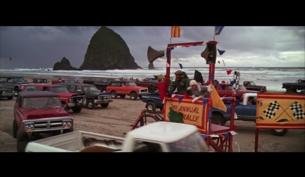 Screenshot of the truck rally scene in The Goonies filmed by Haystack Rock (in the background) on Cannon Beach.